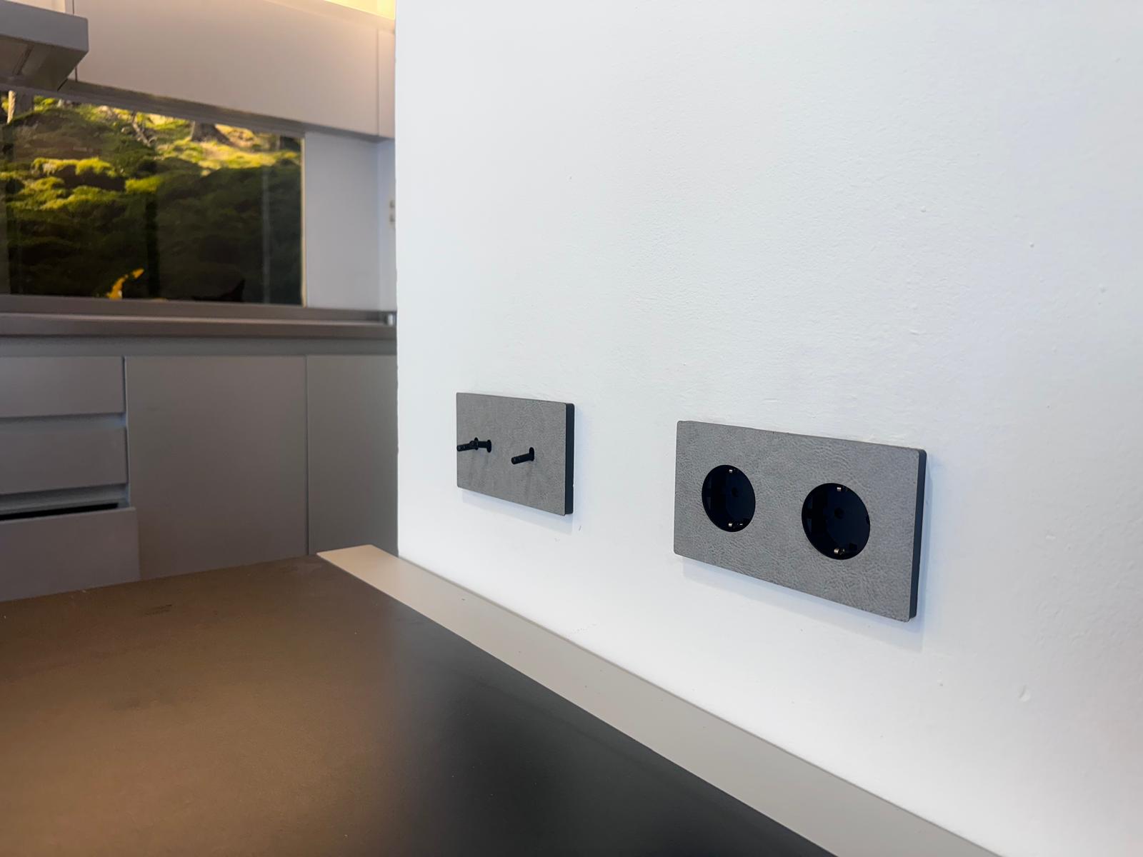 Mecanismos e interruptores decorativos acabados en cuero gris para reformas de diseño. 2 mecanismos e interruptores decorativos
