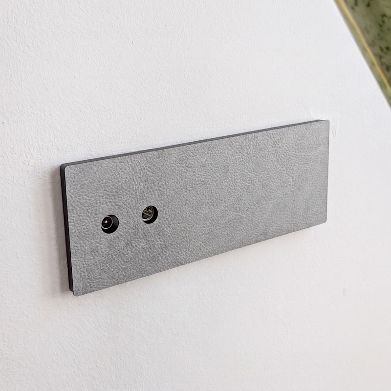 Mecanismos e interruptores decorativos acabados en cuero gris para reformas de diseño. 4 toma antena tv satelital